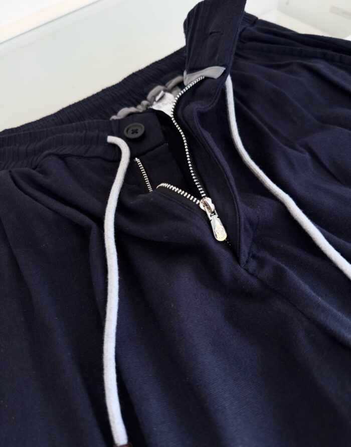 Pantaloni casual navy con zip, bottoni e cintura regolabile per comfort e stile quotidiano.