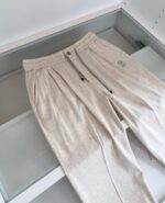 Pantaloni casual chiari con elastico, logo minimalista, perfetti per look comodi e versatili.