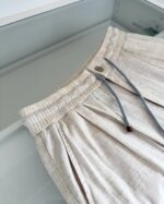 Shorts beige casual con dettagli di colore, vita elasticizzata e pieghe eleganti.