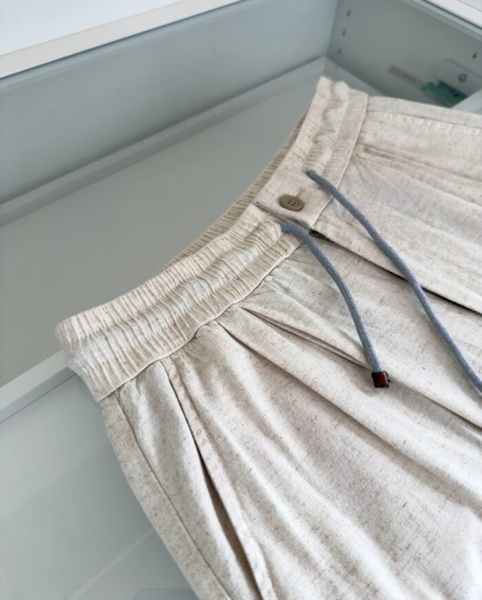 Shorts beige casual con dettagli di colore, vita elasticizzata e pieghe eleganti.