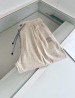 Pantaloni jogger beige con elastico, laccio a contrasto, logo discreto, stile casual e versatile.