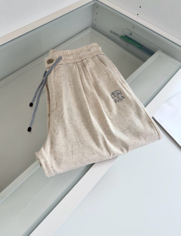 Pantaloni jogger beige con elastico, laccio a contrasto, logo discreto, stile casual e versatile.