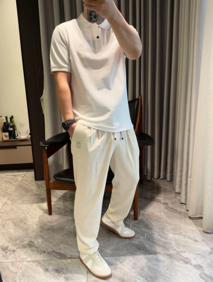 Persona in abbigliamento casual elegante in ambiente moderno con tocco sofisticato.