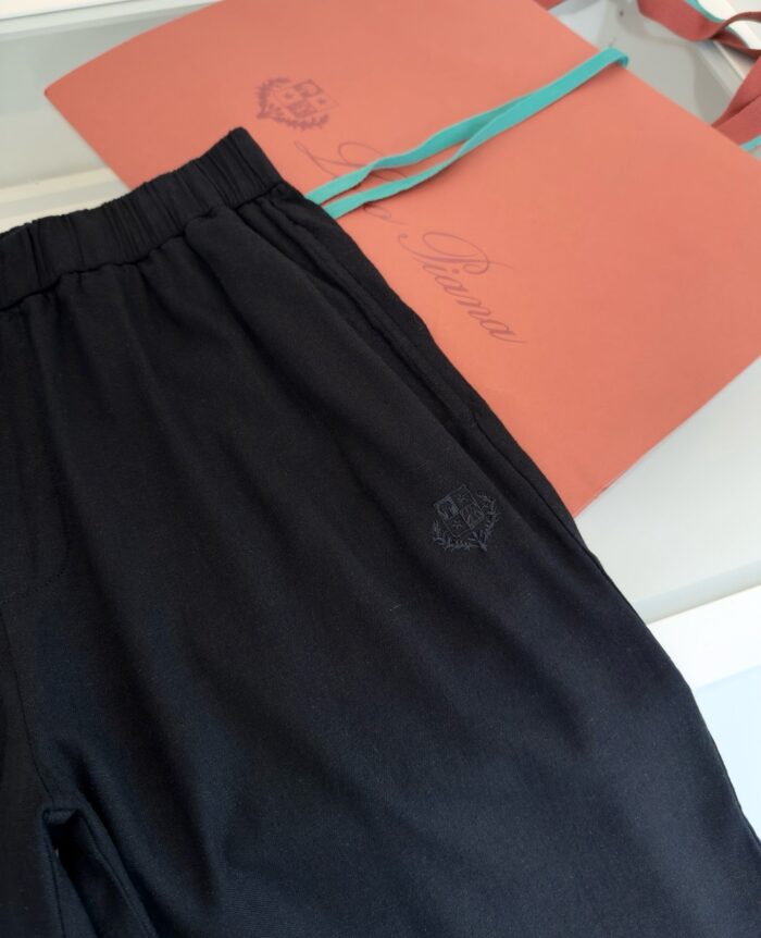 Pantaloni neri casual eleganti con confezione regalo teal e fiocco, stile raffinato e comodo.