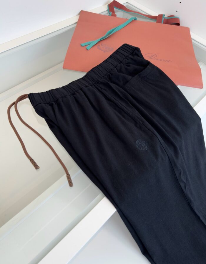 Pantaloni neri casual con borsa colorata, look moderno e confortevole per il tempo libero.