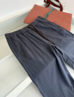 Pantaloni grigi comodi e borsa elegante per un look casual sofisticato.