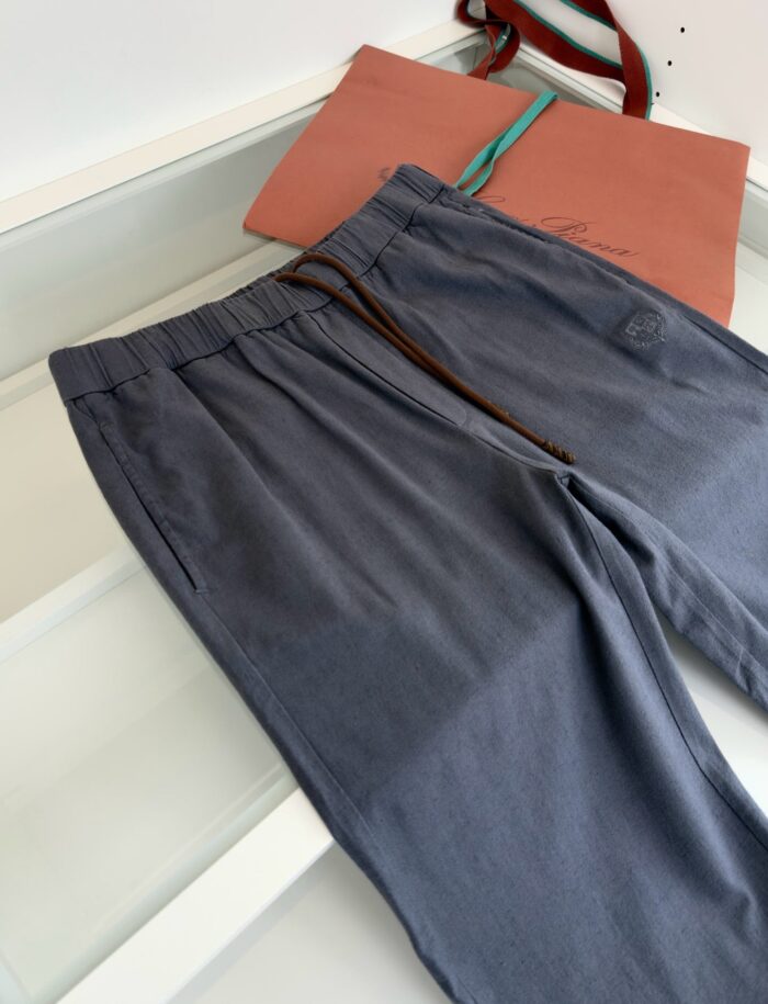 Pantaloni grigi comodi e borsa elegante per un look casual sofisticato.
