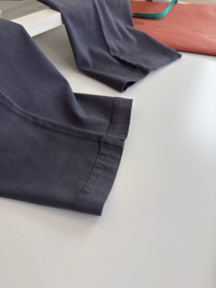 Pantaloni moderni in tessuto scuro con impunture di qualità e dettaglio di cucitura elegante.