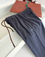 Pantaloni navy con elastico e pouch corallo elegante, accessori moda casual e confortevole.