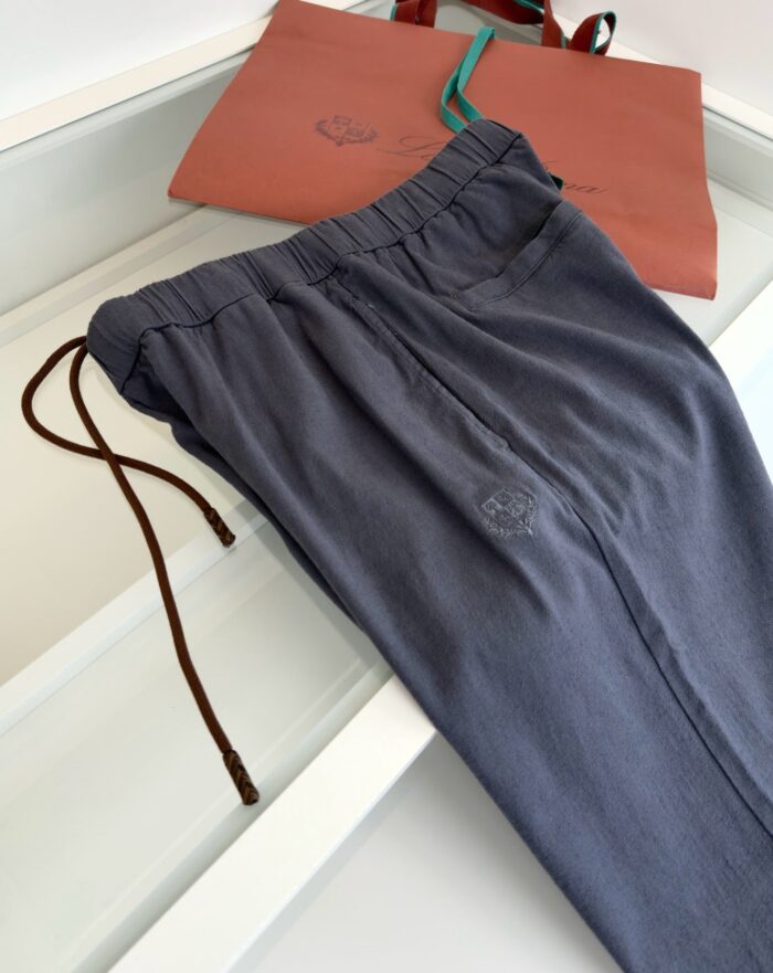 Pantaloni navy con elastico e pouch corallo elegante, accessori moda casual e confortevole.