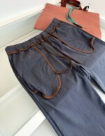 Pantaloni casual blu con tasche a contrasto e cinturino elasticizzato, abbinati a tote colorata.