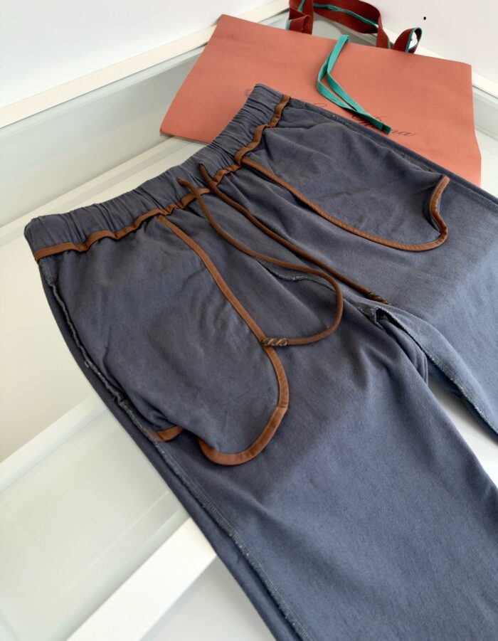 Pantaloni casual blu con tasche a contrasto e cinturino elasticizzato, abbinati a tote colorata.