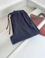 Pantaloni navy casual con elastico e coulisse, accessorio in cuoio, stile confortevole ed elegante.