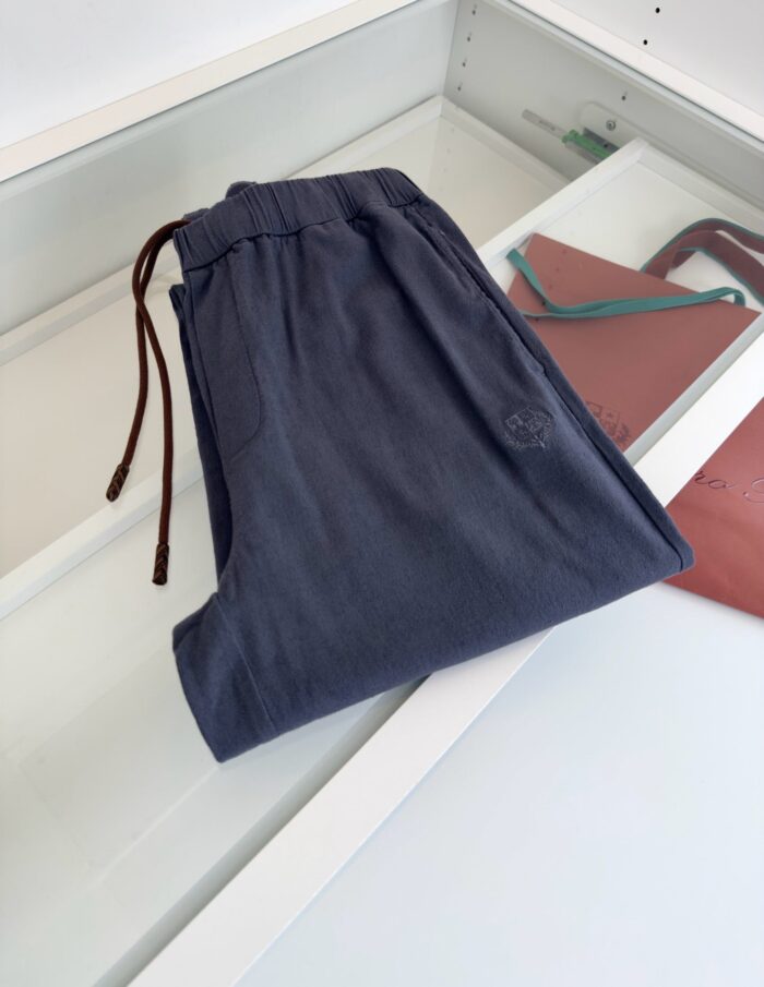 Pantaloni navy casual con elastico e coulisse, accessorio in cuoio, stile confortevole ed elegante.