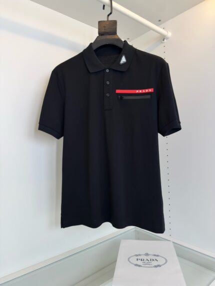Poloshirt nero con tasca a righe rosse e bianche, stile sofisticato e moderno.