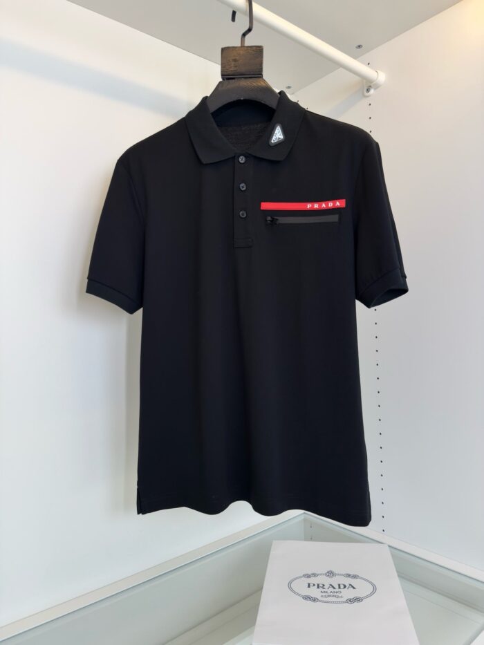 Poloshirt nero con tasca a righe rosse e bianche, stile sofisticato e moderno.