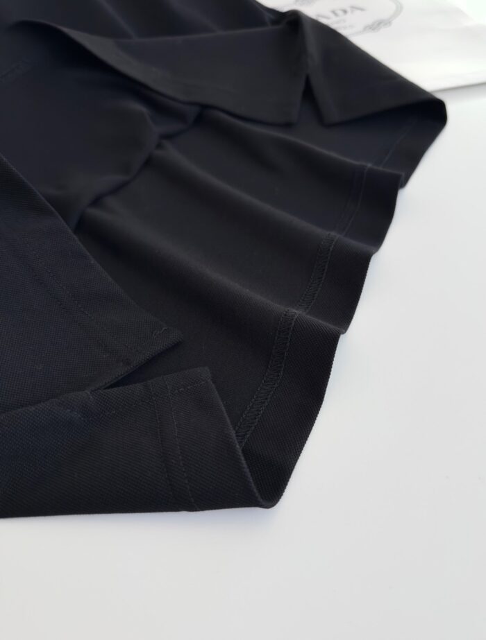 Maglietta polo nera elegante con dettagli di alta sartoria e stile versatile.