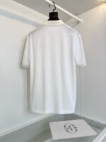 Maglietta polo bianca elegante su appendiabiti, stile minimalista e servizio curato.