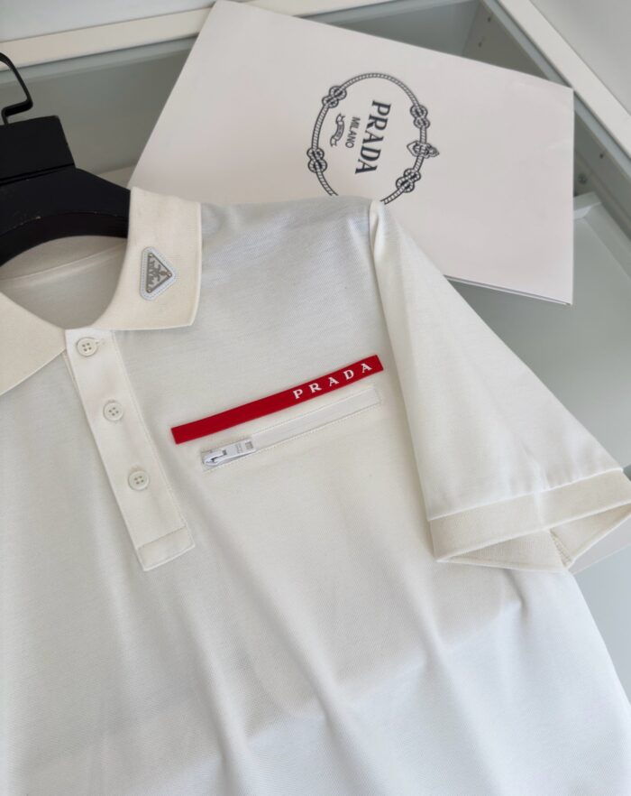 Camicia polo bianca Prada con logo rosso, stile elegante e di lusso.