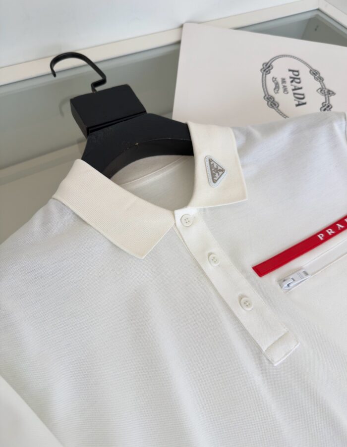 Camicia polo bianca Prada con logo triangolare e dettagli eleganti, perfetta per uno stile sofisticato.