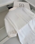Maglietta polo bianca di lusso, elegante e raffinata, in ambientazione moderna e ordinata.