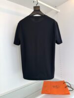 Maglietta nera semplice con borsa arancione, stile moderno e casual, elegante e minimalista.