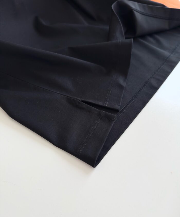Tessuto nero sintetico elegante con pieghe e cuciture, ideale per moda e design moderni.