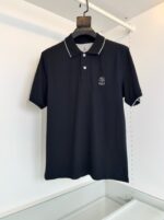 Maglietta polo nera elegante con dettaglio bianco, logo discreto e design classico per ogni occasione.