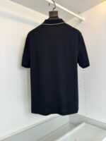 Maglietta polo nera, elegante e versatile, vista da dietro su sfondo bianco minimalista.