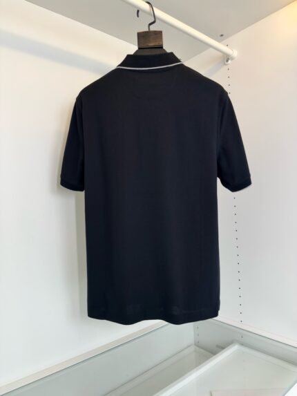 Maglietta polo nera, elegante e versatile, vista da dietro su sfondo bianco minimalista.
