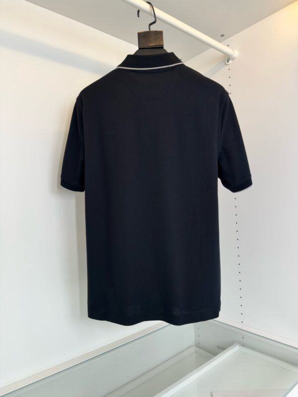 Maglietta polo nera, elegante e versatile, vista da dietro su sfondo bianco minimalista.