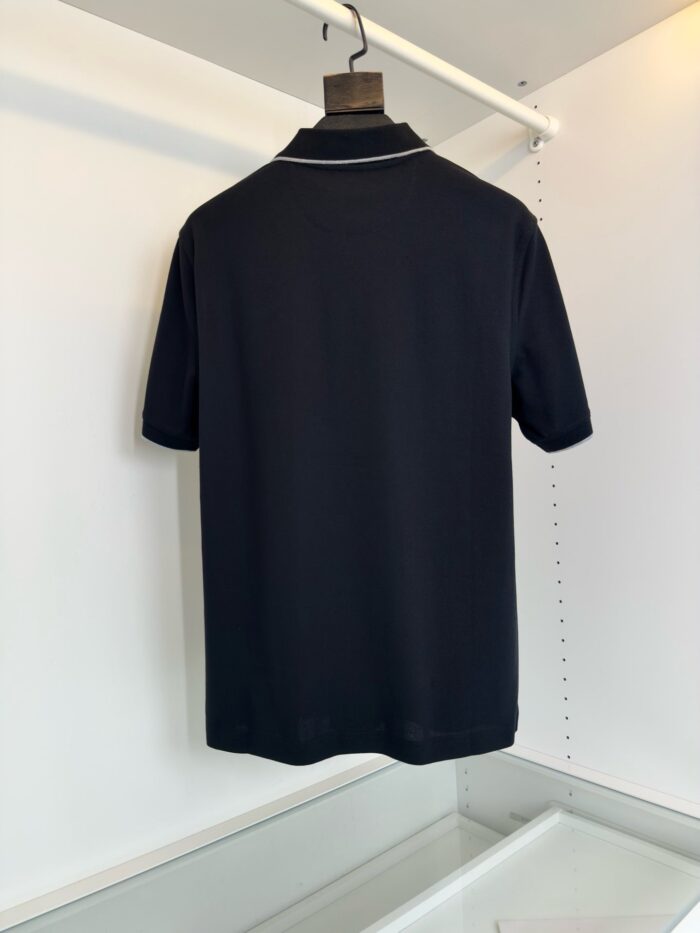 Maglietta polo nera, elegante e versatile, vista da dietro su sfondo bianco minimalista.