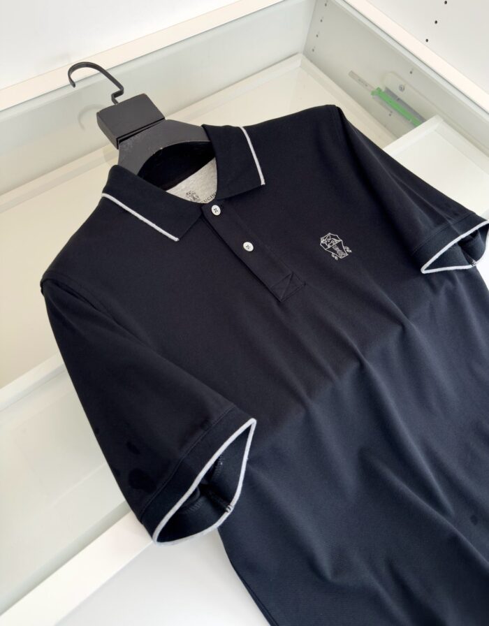 Maglietta polo nera con dettagli bianchi e logo discreto, stile elegante e sporty.
