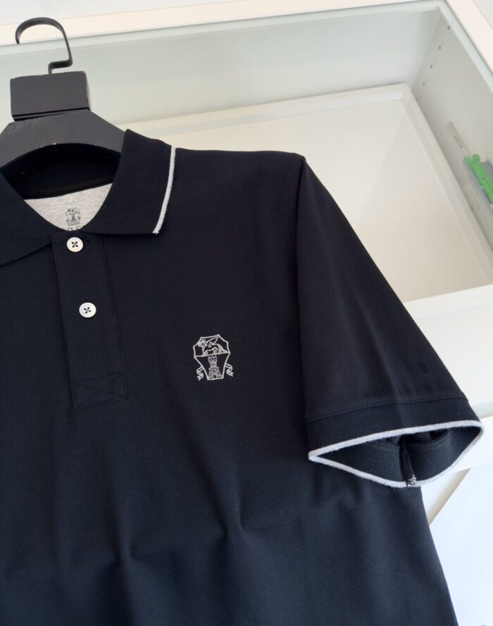 Polo nera con logo elefante ricamato e dettagli a contrasto in bianco elegante e versatile.