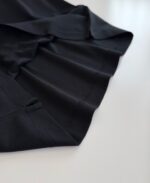 Vestito nero elegante con pieghe precise e dettagli di sartoria, ideale per ogni occasione sofisticata.