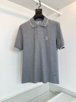 Maglietta polo grigia con dettaglio bianco, logo sottile, stile casual e versatile.