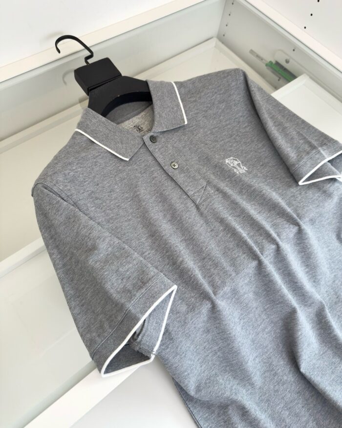 Maglietta polo grigia con logo, collo con bordino bianco e design minimalista elegante.