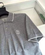 Maglietta polo grigia con ricamo sottile, dettagli eleganti e design classico.