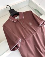 Maglietta polo marrone con colletto a contrasto bianco e logo ricamato sul petto.