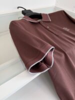 Maglietta polo marrone elegante con dettagli grigi, stile classico e look versatile.