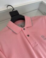 Maglietta polo rosa con logo, dettagli a contrasto e stile casual elegante.
