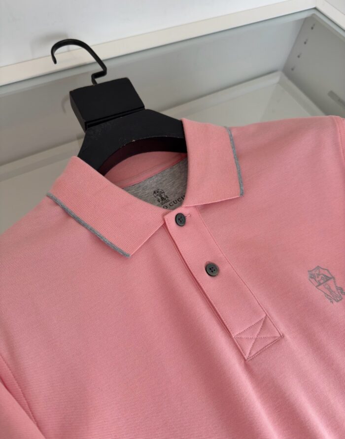 Maglietta polo rosa con logo, dettagli a contrasto e stile casual elegante.