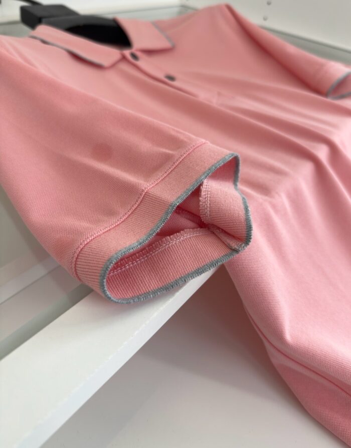 Maglietta polo rosa con dettagli grigi, stile casual e tessuto leggero e confortevole.