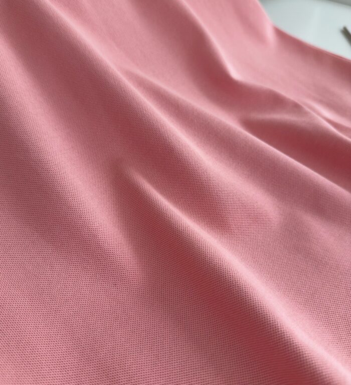 Fazzoletto rosa pastello in tessuto morbido, elegante e versatile per abbigliamento e decorazioni.