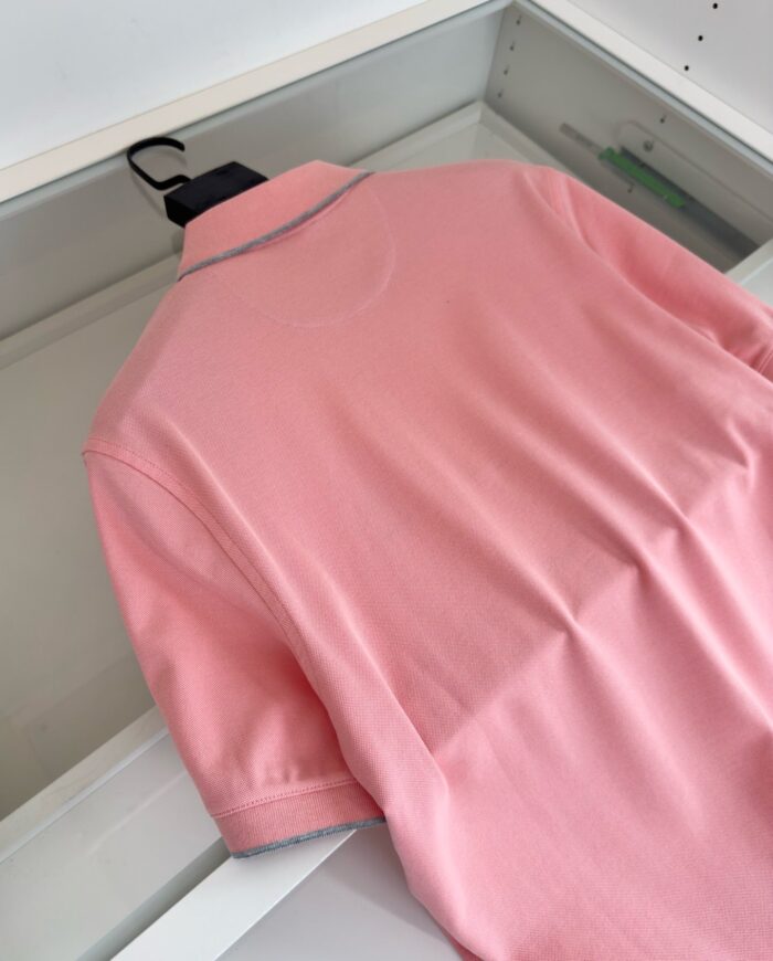 Maglietta polo rosa chiaro, elegante e casual, morbida e di alta qualità, su appendiabiti.