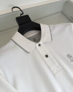 Maglietta polo bianca con dettagli grigi e logo ricamato elegante, stile moderno e versatile.