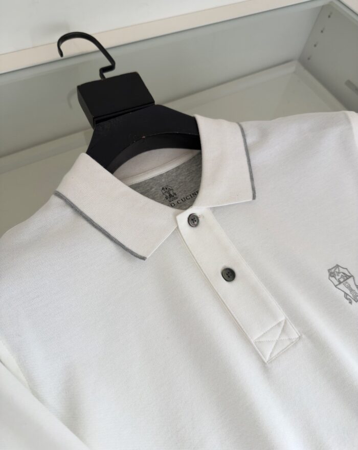Maglietta polo bianca con dettagli grigi e logo ricamato elegante, stile moderno e versatile.