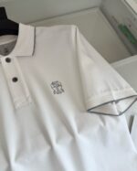 Maglia polo bianca con dettaglio contrasto e logo sottile, stile casual e sofisticato.