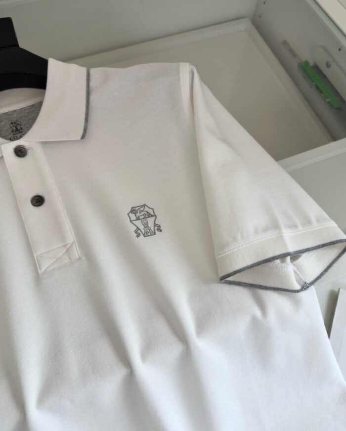 Maglia polo bianca con dettaglio contrasto e logo sottile, stile casual e sofisticato.