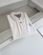 Maglietta polo bianca con colletto a contrasto e logo ricamato sul petto.